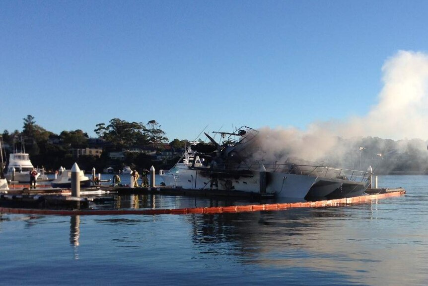 A yacht smoulders after a massive blaze engulfed several boats at Cabarita in Sydney, on December 2, 2013.