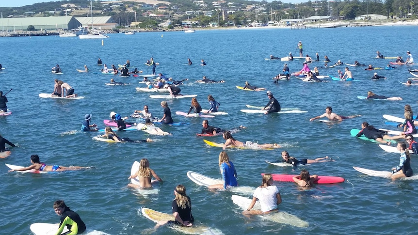 People sit on surfboards