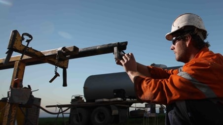 A worker inspecting a drill tube at the Hillside mine location.