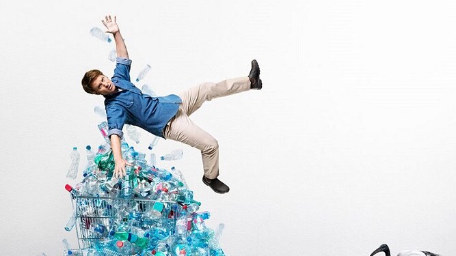 Craig Reucassel hovers above pile of plastic water bottles