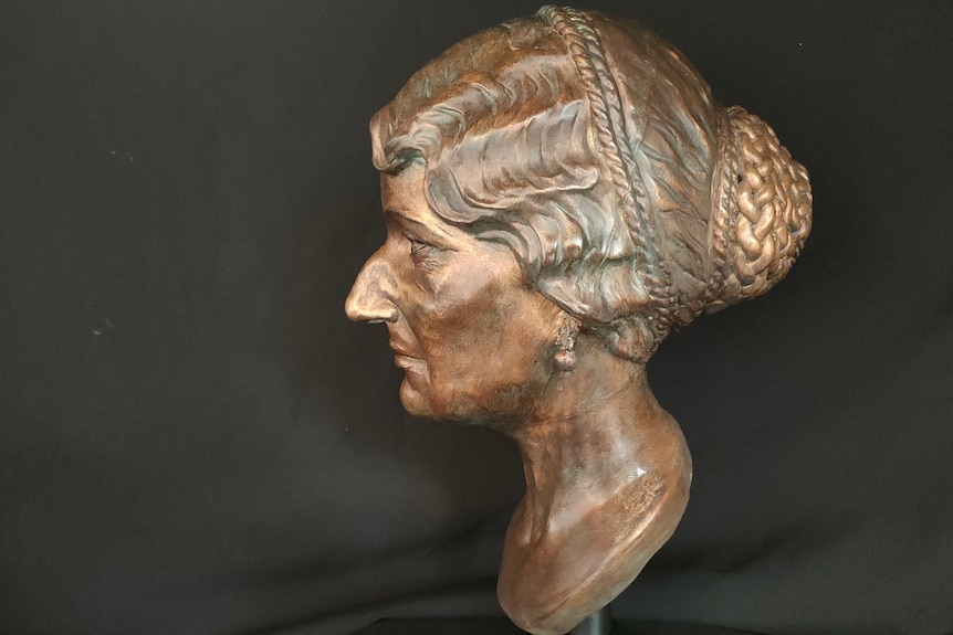 A bronze sculpture of a older woman's head, looking sideways