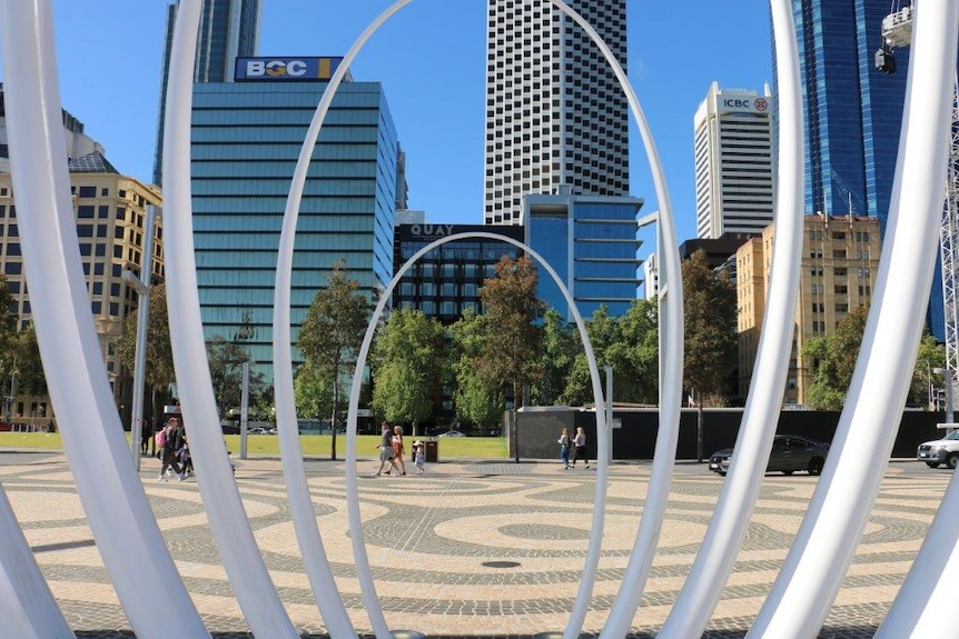 Metal oval poles the frame the Perth skyline in the background.