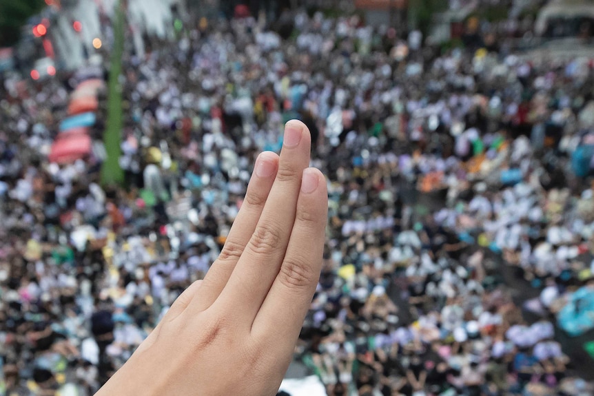 A pro-democracy protester raises a three-finger salute at a rally in Bangkok.