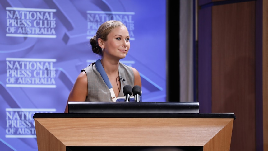 Grace Tame speaks at a lecturn at the national press club 