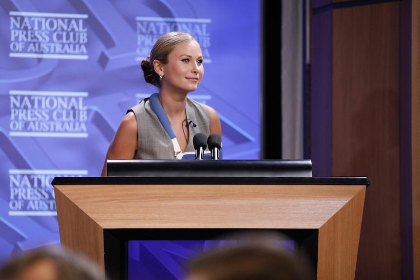 Grace Tame speaks at a lecturn at the national press club 