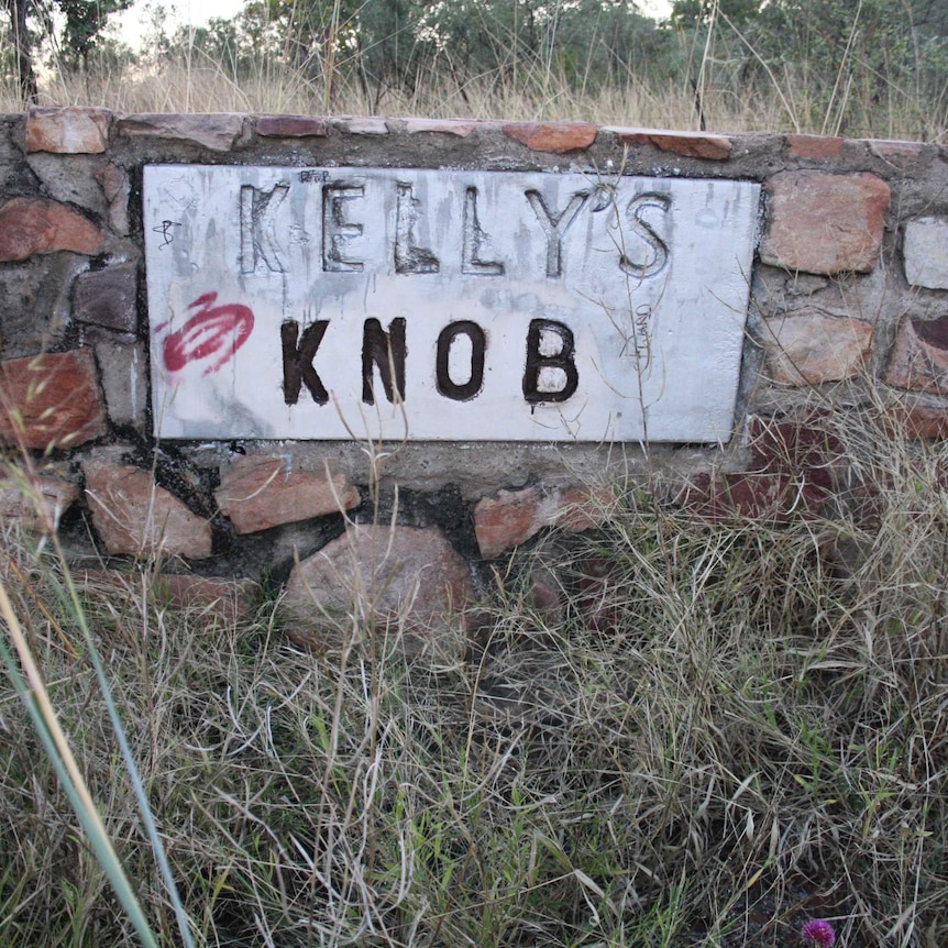 A stone sign with graffiti for Kelly's Knob