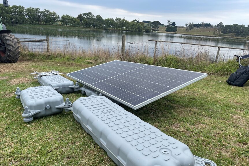 A solar panel attached to floats about to go into a dam.