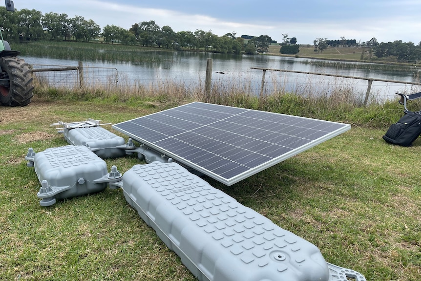 A solar panel attached to floats about to go into a dam.