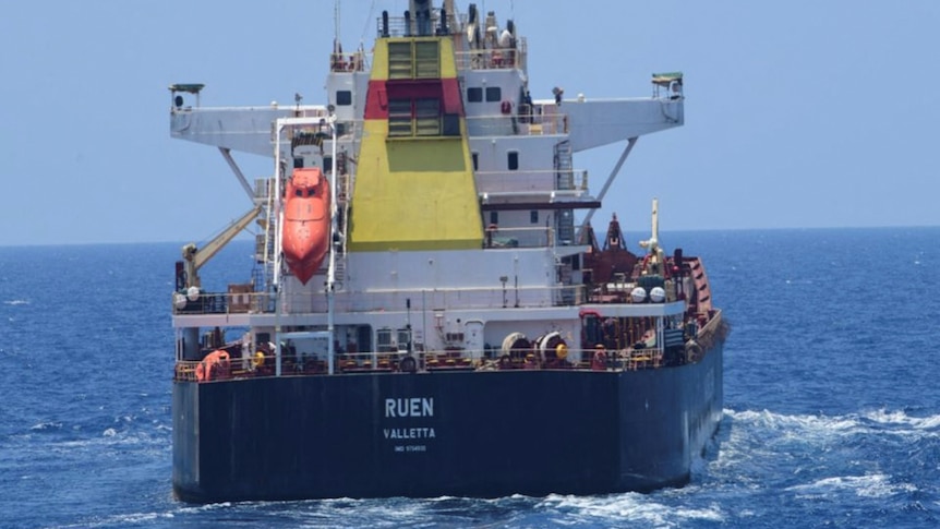 A cargo ship is seen from behind with the life raft visible. 