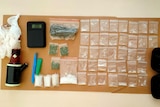 Methamphetamine and cannabis laid out as evidence on a table. 