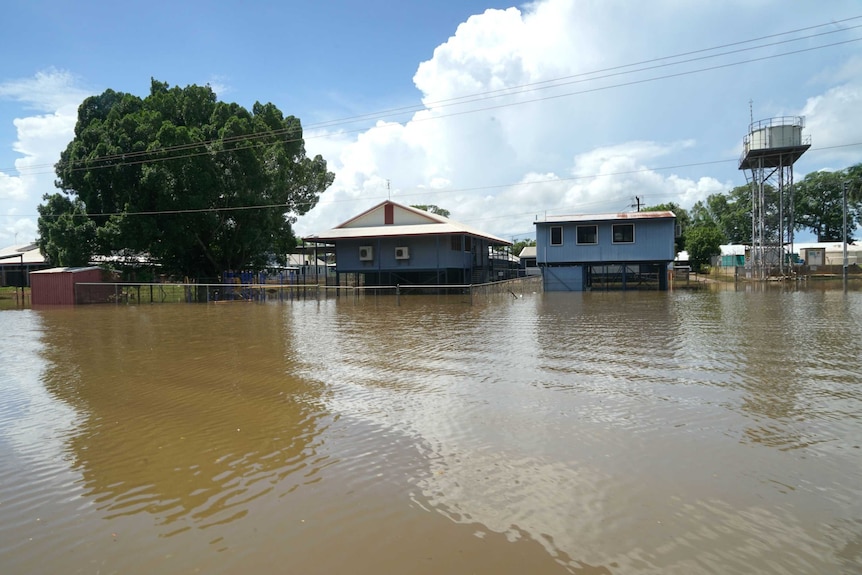 Floodwaters surrounding a number of buildings and a water tower.