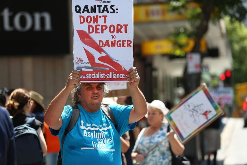 Seorang pengunjuk rasa di luar RUPS Qantas di Brisbane.