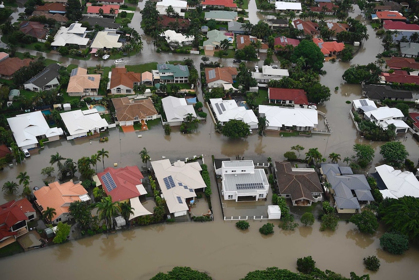 An aerial view of homes surrounded by flooded streets in a Townsville suburb.