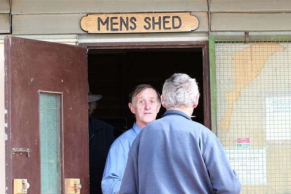 Two men standing near a door.