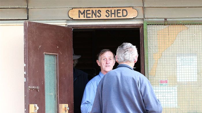 Two men standing near a door.