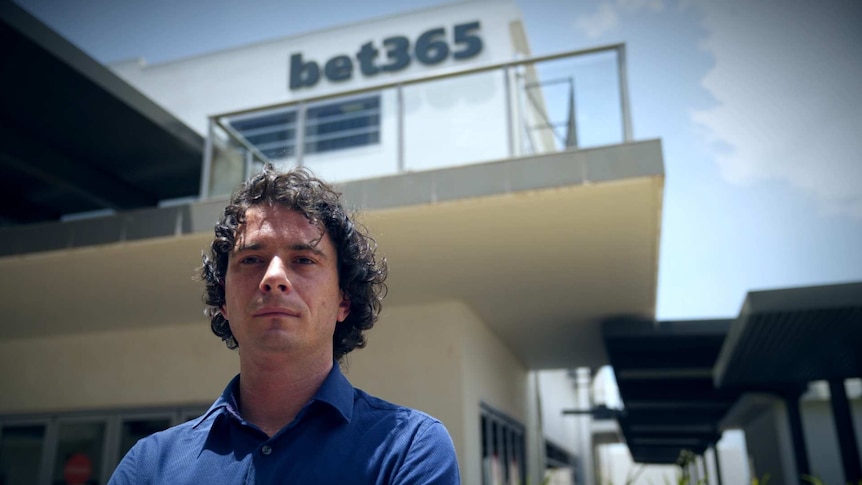 Young man standing in front of a bet365 building.