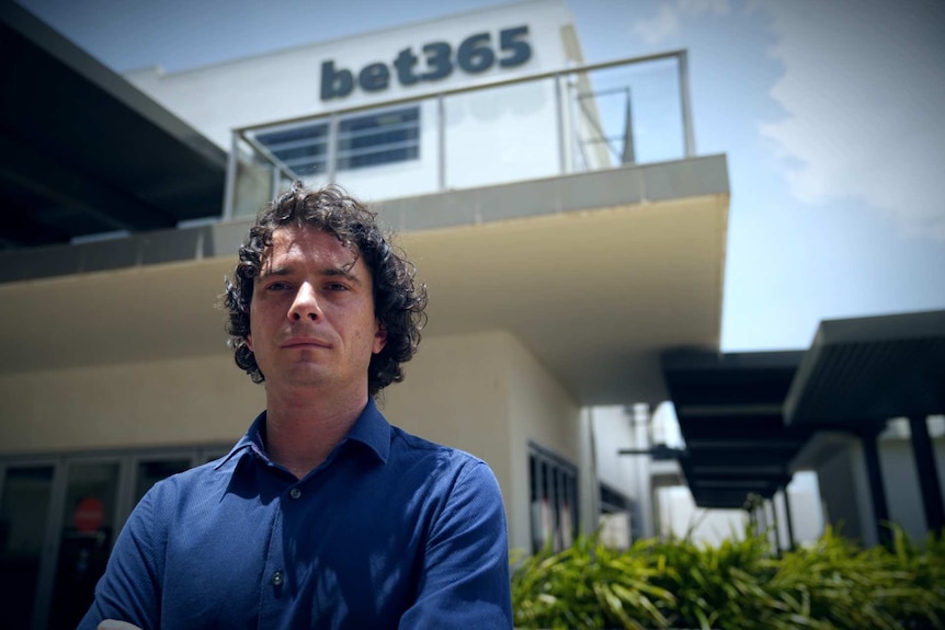 Young man standing in front of a bet365 building.