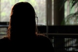 Woman's head in silhouette against a window