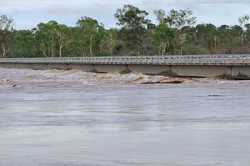 Floodwaters rise and swirl under Macrossan Bridge,  north-east of Charters Towers.
