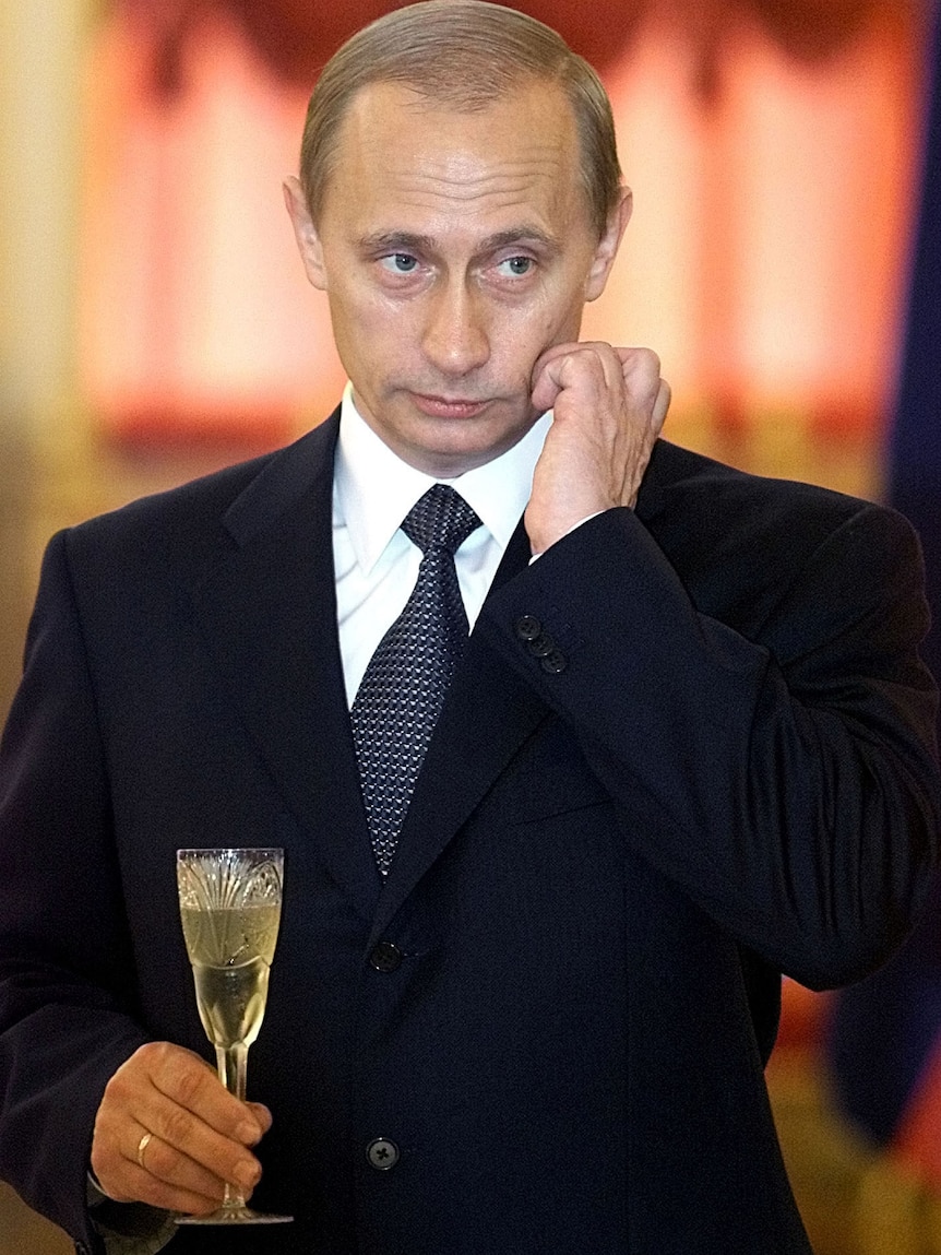 Vladimir Putin holds a glass of champagne 