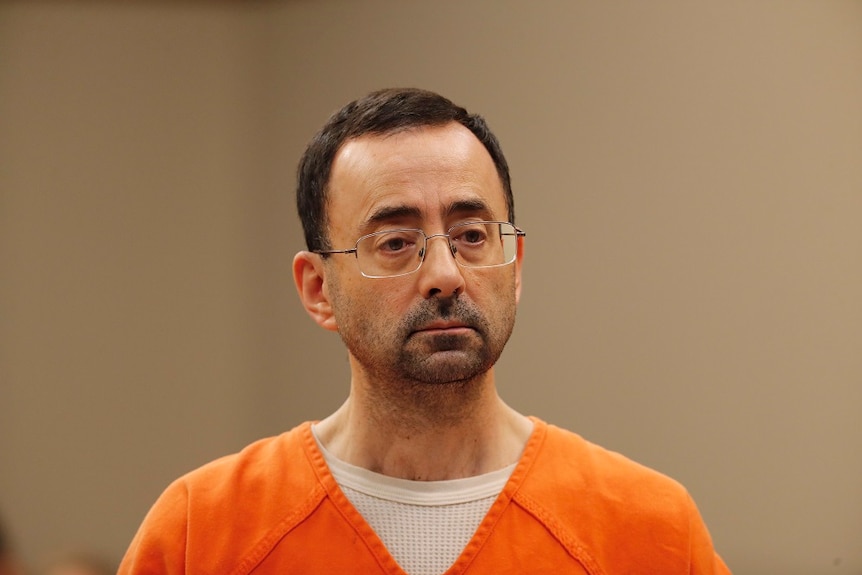 A close up shot of Larry Nassar in court wearing an orange jumpsuit.