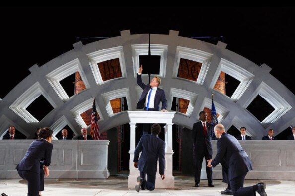 Donald Trump-like Julius-Caesar raises his hand in the air during the Shakespeare in the Park production