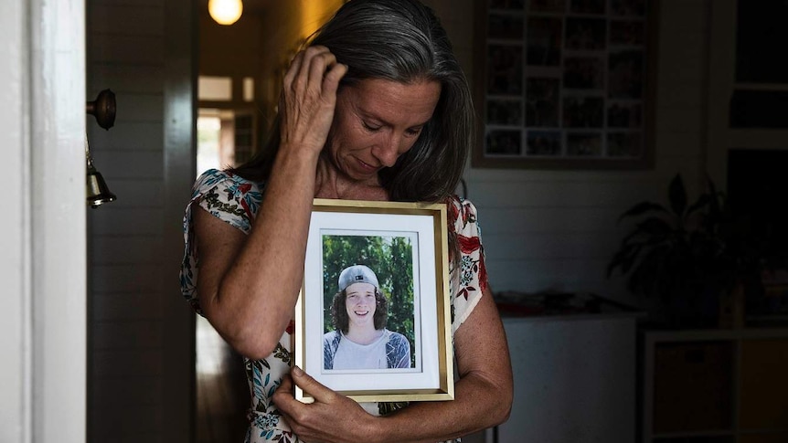 Ursula Wharton holds a photo of her son Joshua.