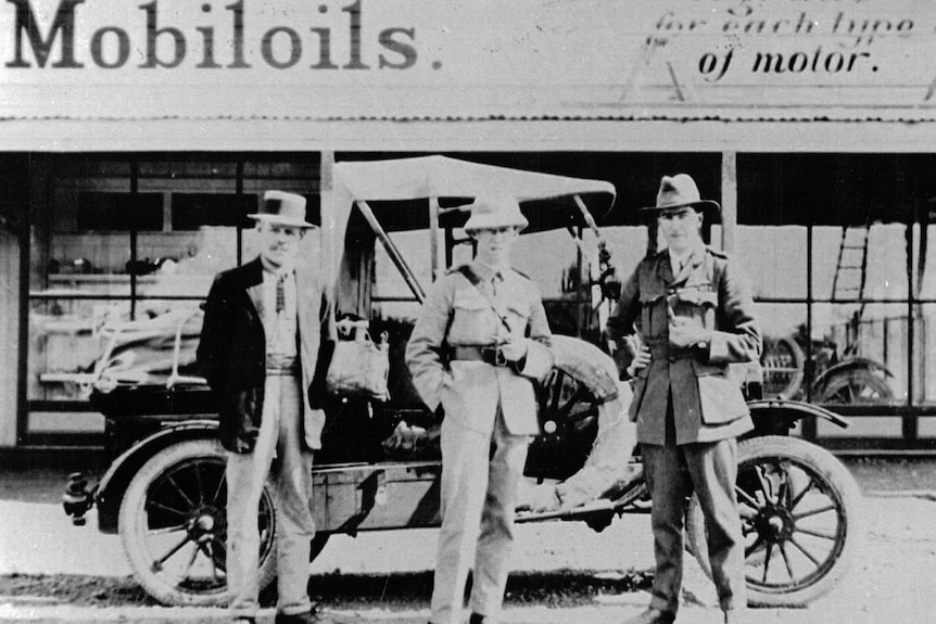 A black and white archive photo of three men standing in front of a Model T Ford in 1919.