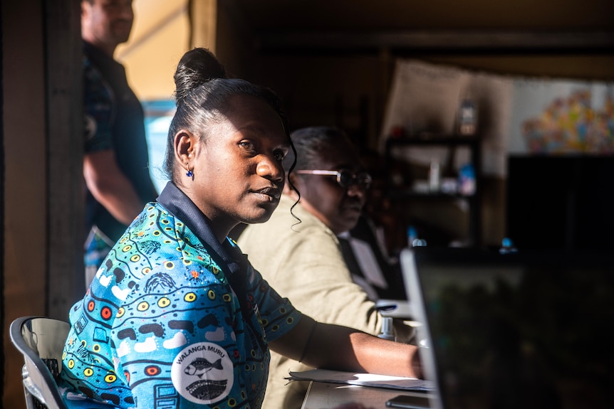 A young girl looks to the side in a classroom.