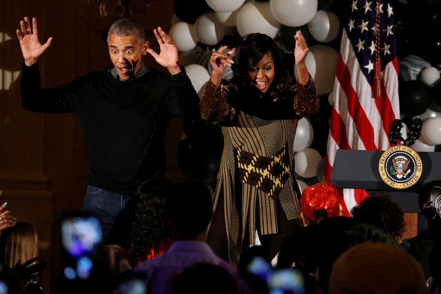 Barack Obama and Michelle Obama dance along with children at a Halloween reception at the White House.