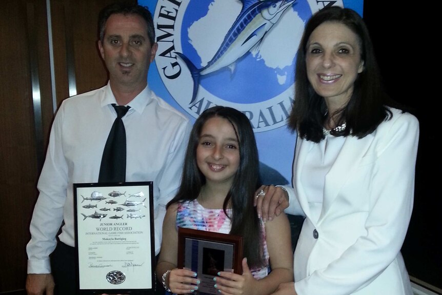 10yo girl with her parents, holding a certificate