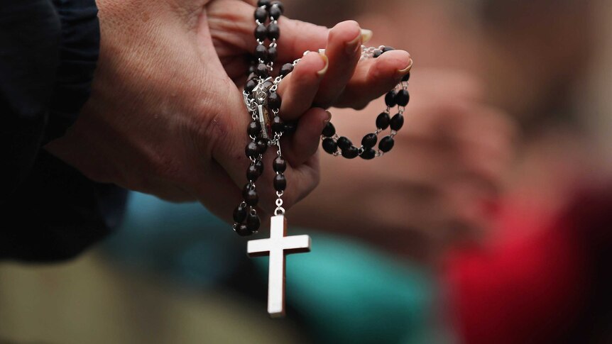 A Catholic worshiper holds rosary beads