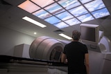 David Smiedt looking up at an LSD screen adorned with an image of Bondi Beach