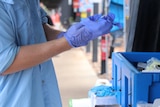 a person wearing gloves holding a syringe