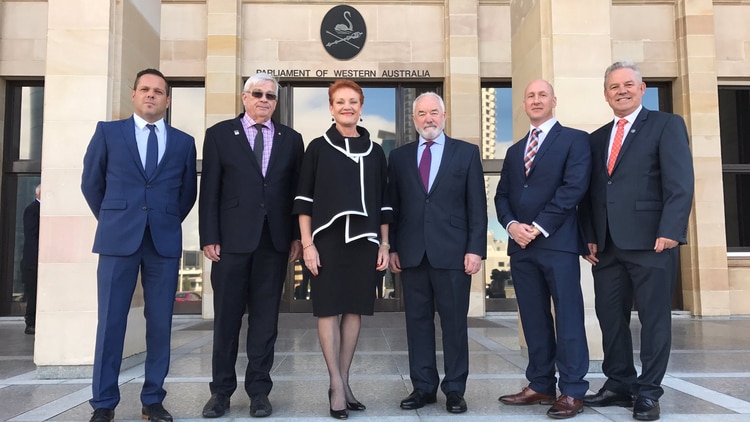 Six current and former One Nation members stand in front of WA Parliament House.