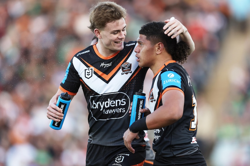 Luke Laulilii celebrates with Wests Tigers NRL teammate Lachlan Galvin after scoring a try.