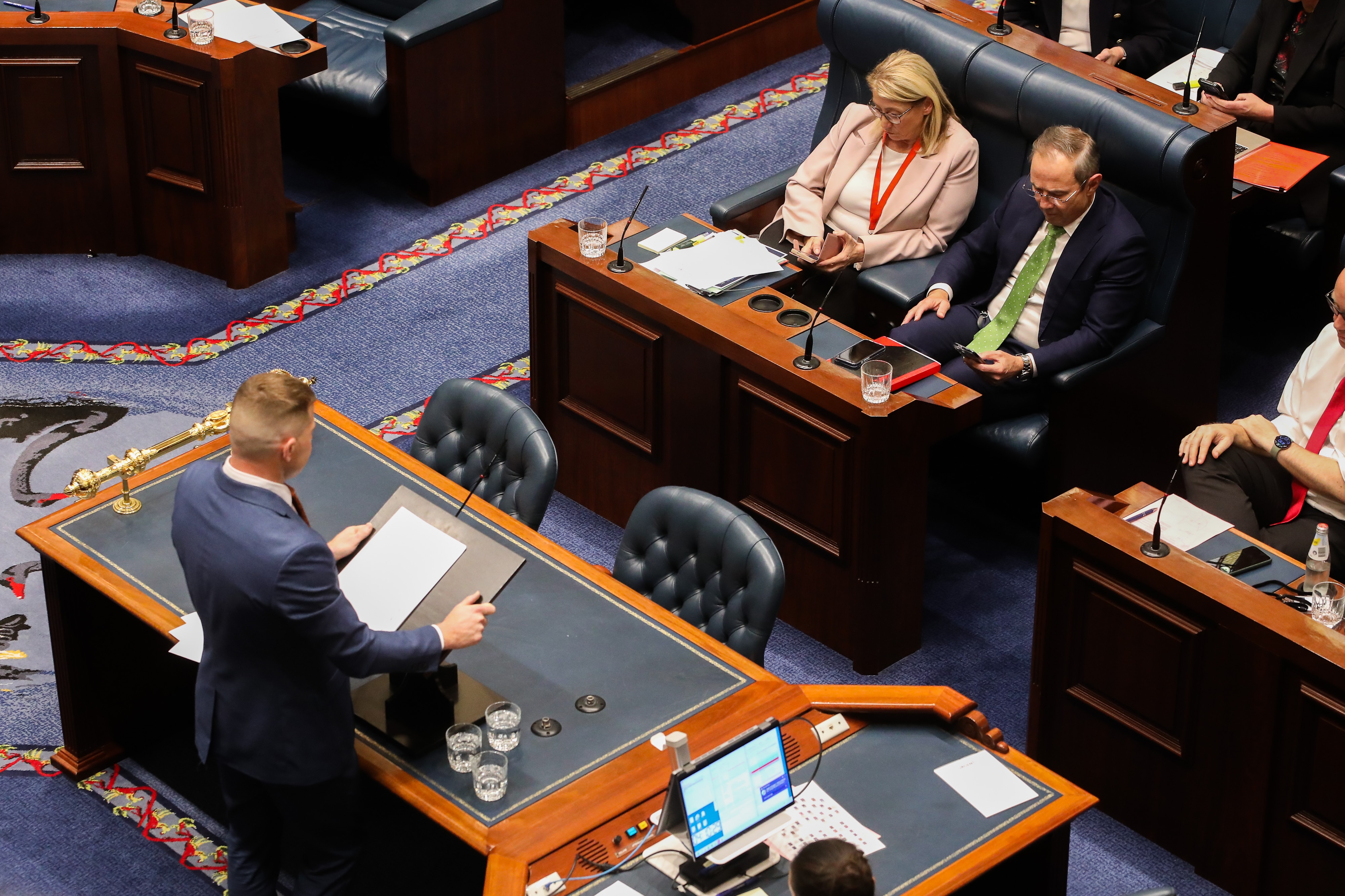 Overhead shot of an MP speaking in Parliament, as other MPs watch on.