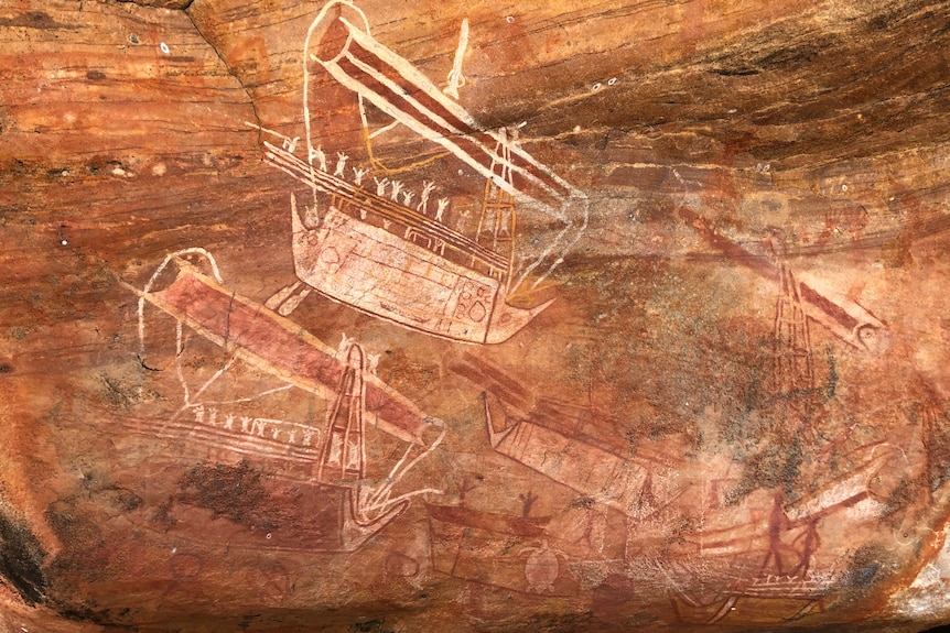 A rock painting in red stone of a sailing boat