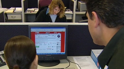 People look at a computer screen in a business