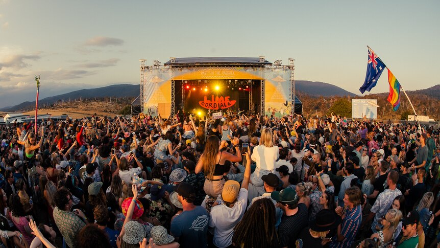 A packed festival crowd watches a band in the early evening at Tasmania's Party In The Paddock festival 