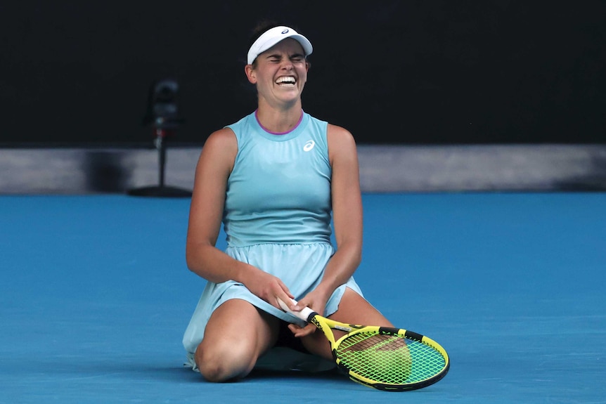 A tennis player kneels on the court and cries after winning a big match at the Australian Open.
