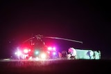 People use umbrellas and sheets to shield from view whatever activity that is taking place at night next to a helicopter