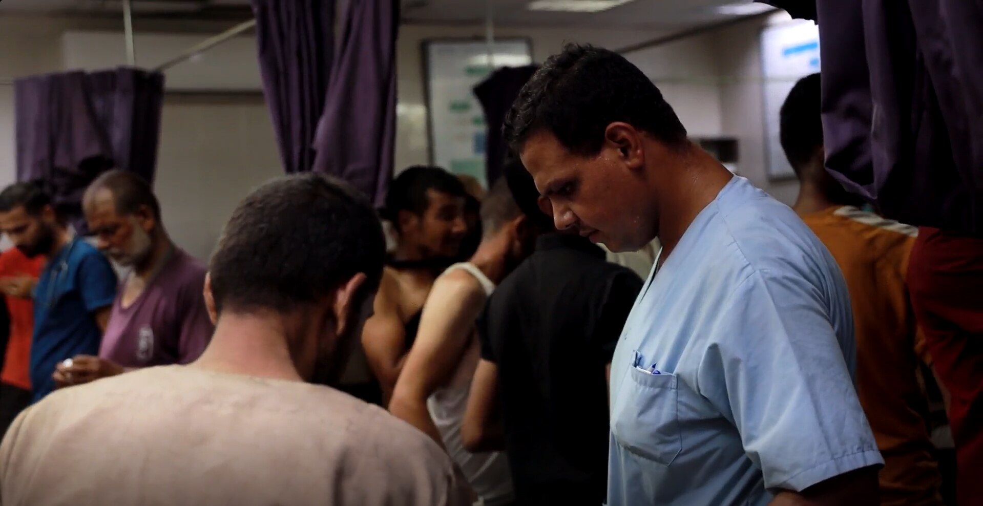 A doctor works in a crowded room