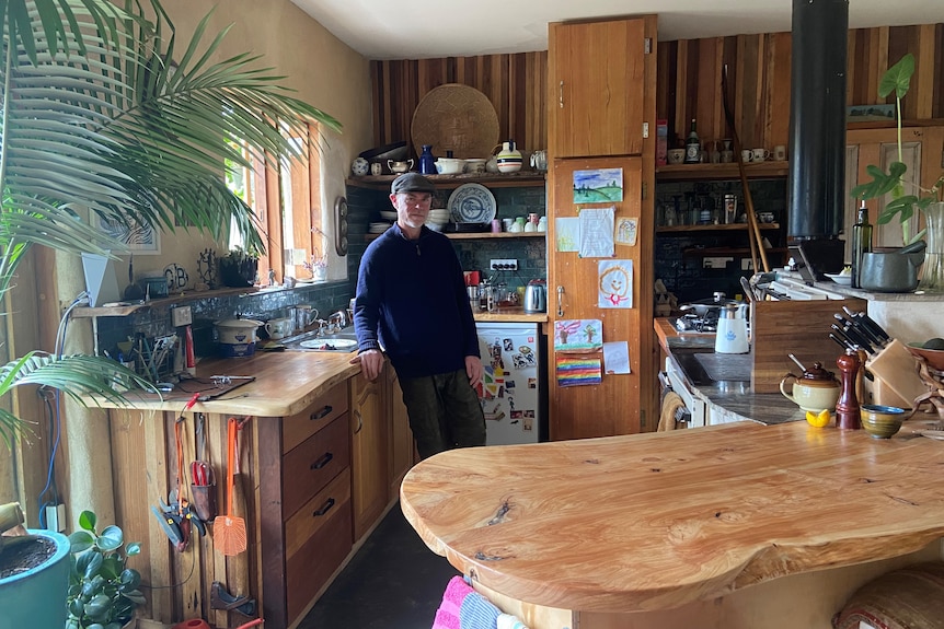 A man standing in kitchen, kitchen made from timber 