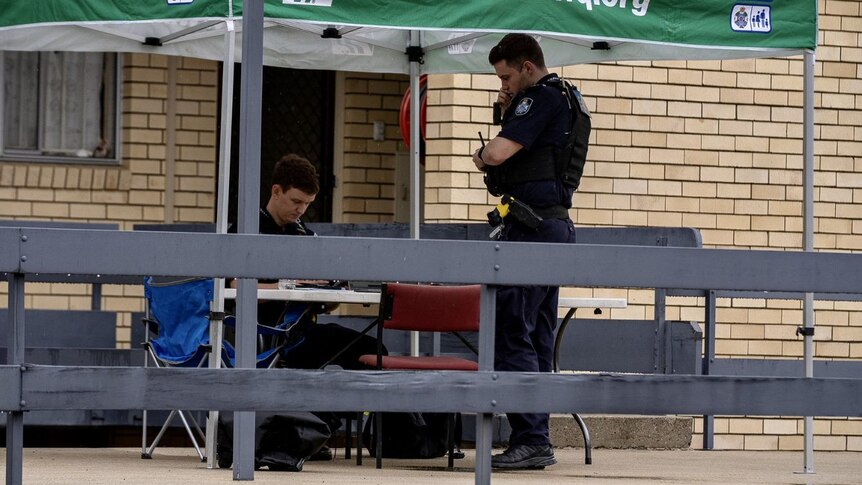 Police stand outside an apartment complex