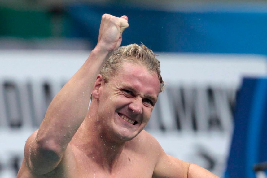Australian Olympic swimmer Brenton Rickard punches the air in celebrating after winning gold in New Delhi, October 2009.