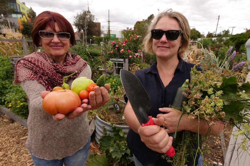 Two women smiling standing in a garden.