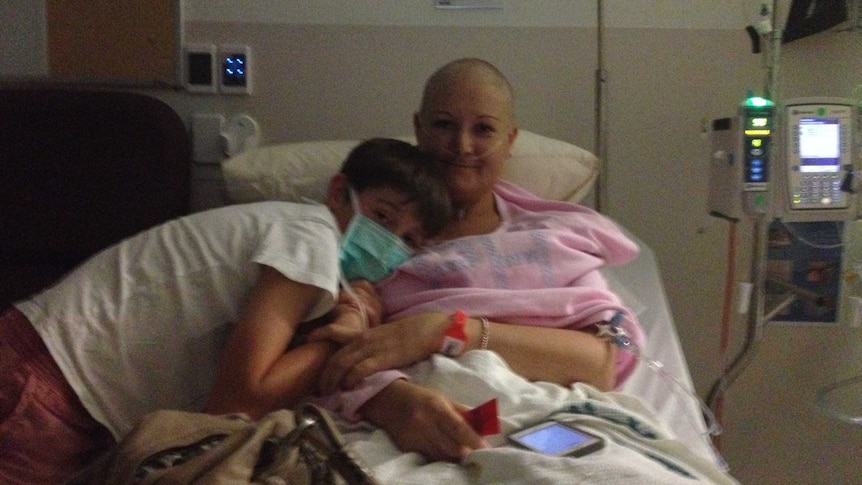 Kylie Willey lies in a hospital bed. Her son is by her side.