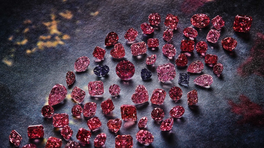 A group of vivid pink, red and violet stones against blue backdrop