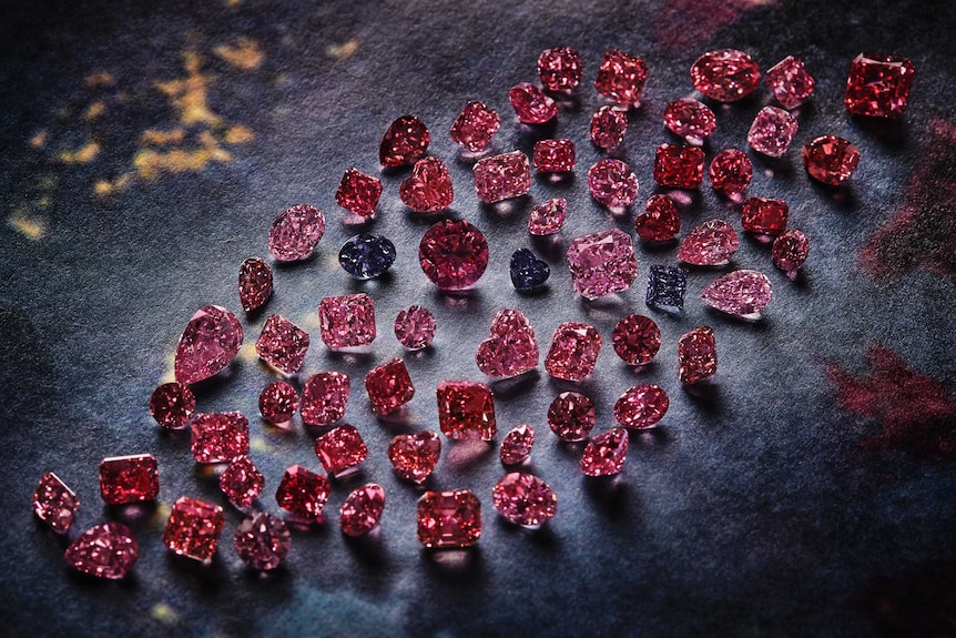 A group of vivid pink, red and violet stones against blue backdrop